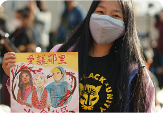 A community member holding a flyer for the Stop Anti-Asian Violence rally