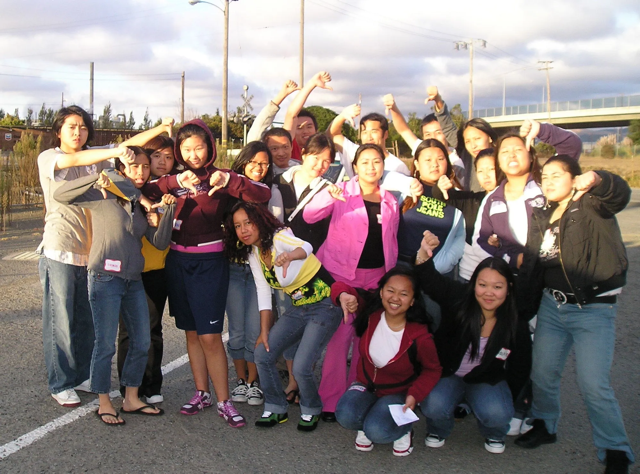 Photo of members of the Asian Youth Advocates (AYA) members from 2005. Sandy is center in the pink two-piece suit, looking extremely cool.